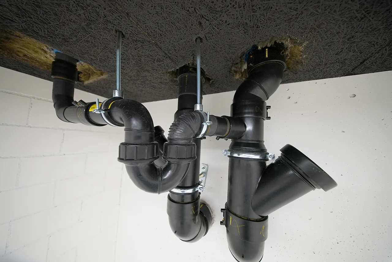 Abwasserleitungen mit Abzweigen an einer Decke