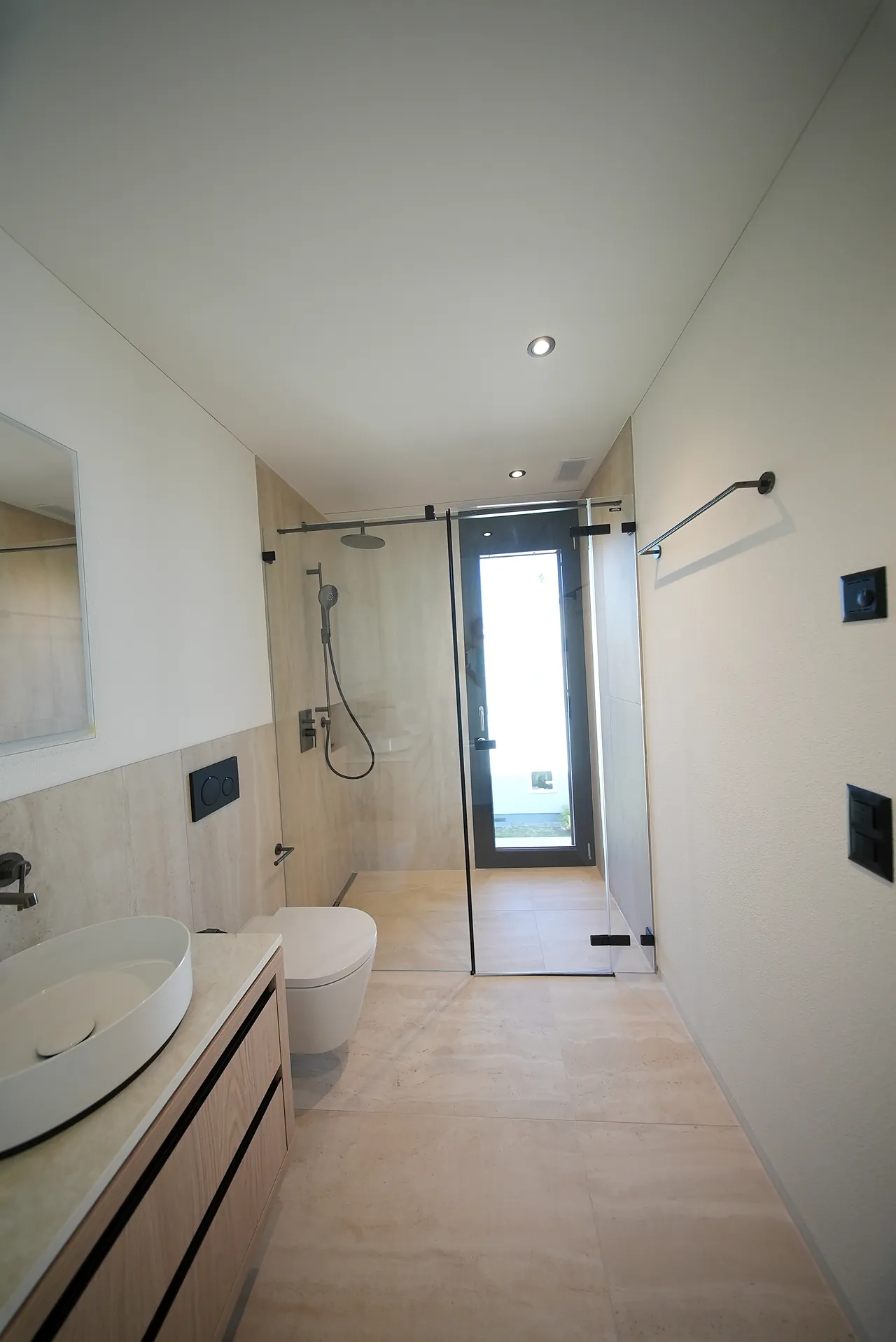 Schmales Badezimmer mit bodenebener Dusche und wandhängendem WC in Ebmatingen