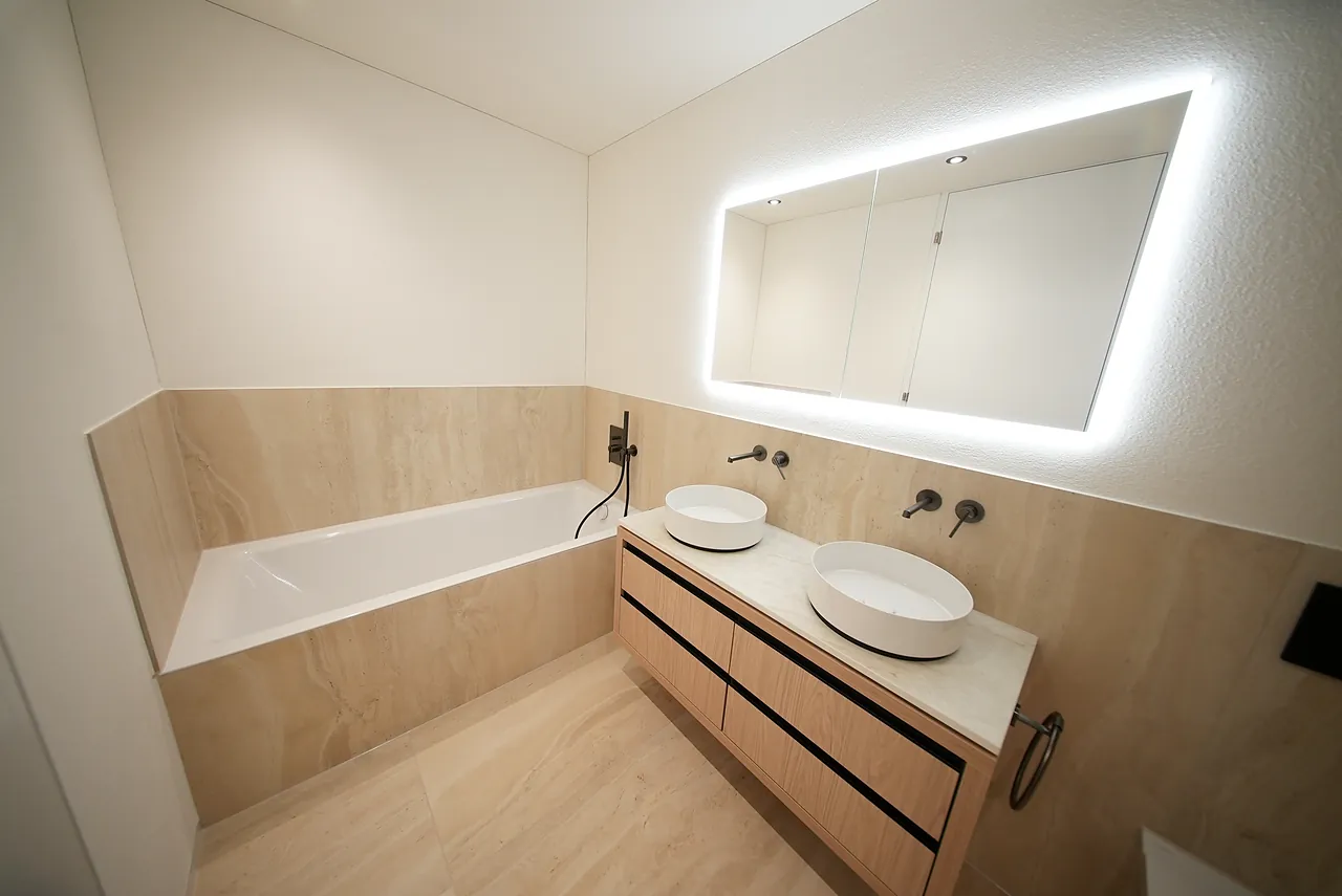 Neues Badezimmer mit Badewanne, Doppelwaschtisch und beleuchtetem Spiegel in Ebmatingen