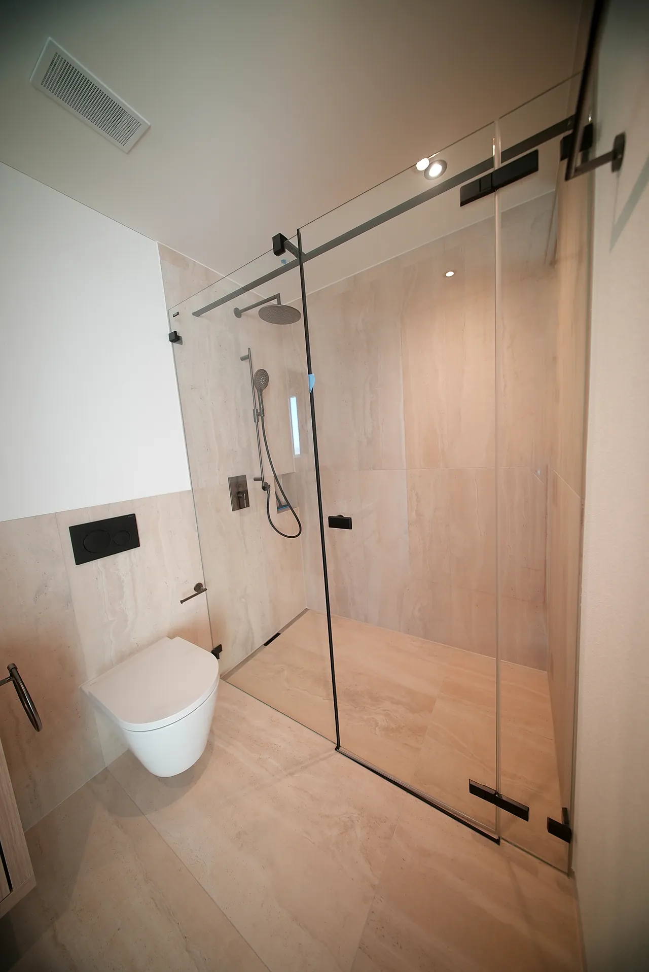Dusche mit Glasschiebetür, Kopfbrause und wandhängendem WC