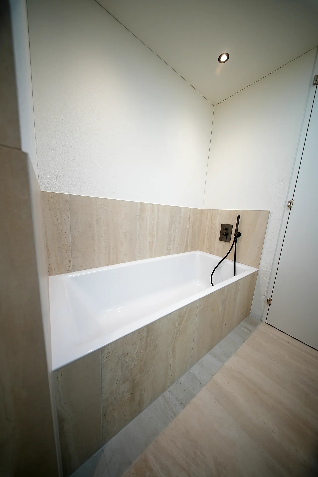 Eingebaute Badewanne mit Wandarmatur in einem Neubau