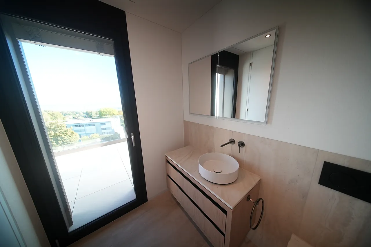 Kleines Badezimmer mit Waschtisch, Spiegel und grossem Fenster