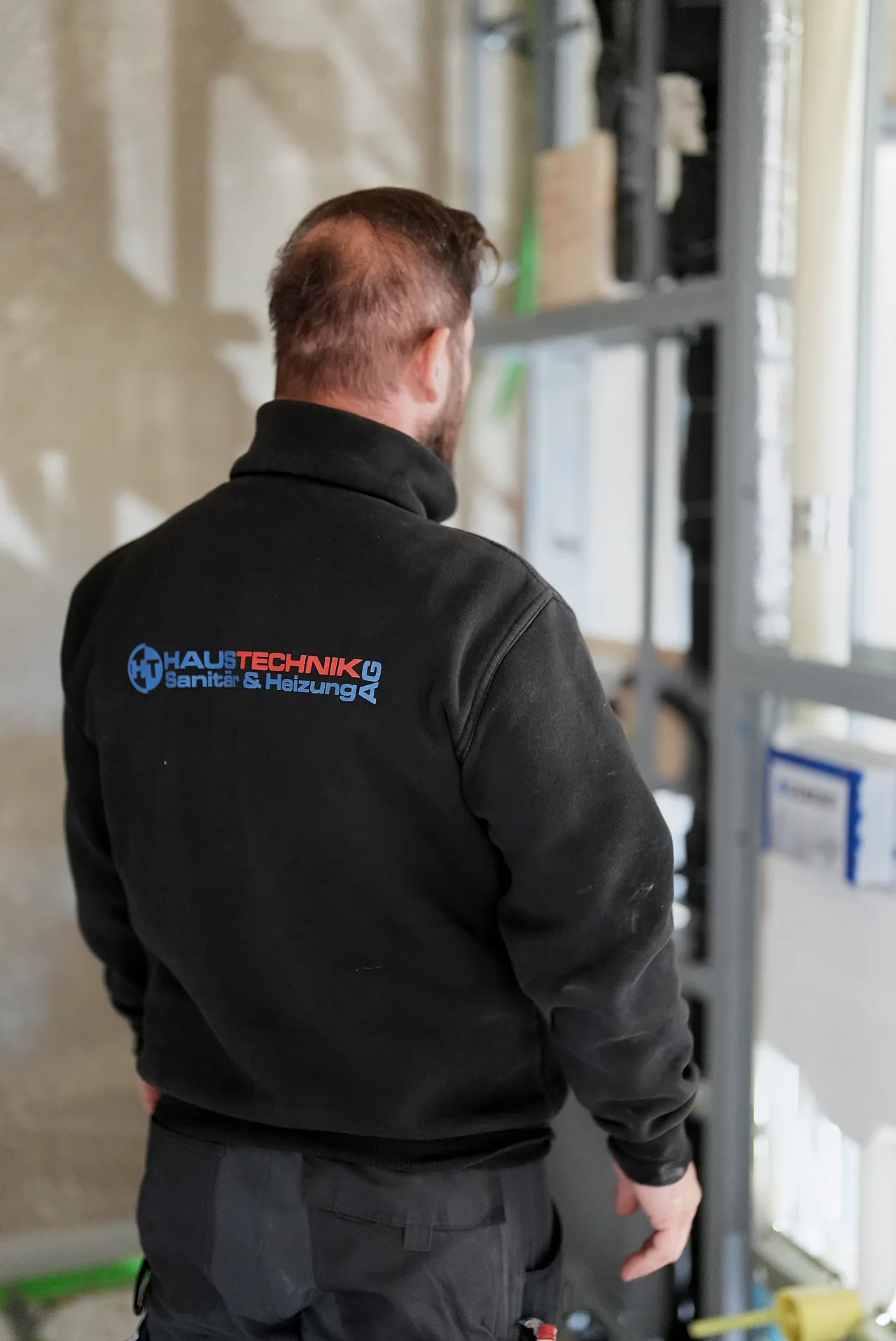 Sanitärmonteur der HT Haustechnik AG an einer Vorwandinstallation im Neubau in Bäretswil
